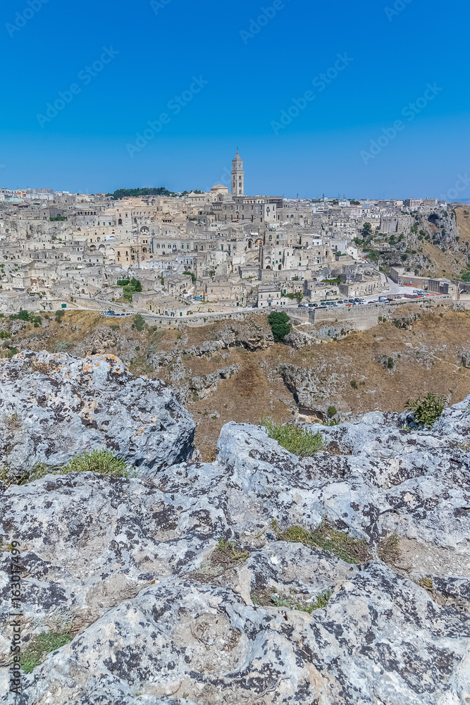 panoramic view of typical stones (Sassi di Matera) and church of Matera UNESCO European Capital of Culture 2019 under blue sky. Basilicata