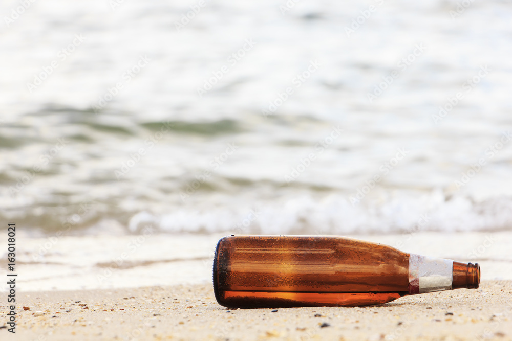 Old beer bottle on beach : pollution concept Old beer bottle on beach : pollution concept