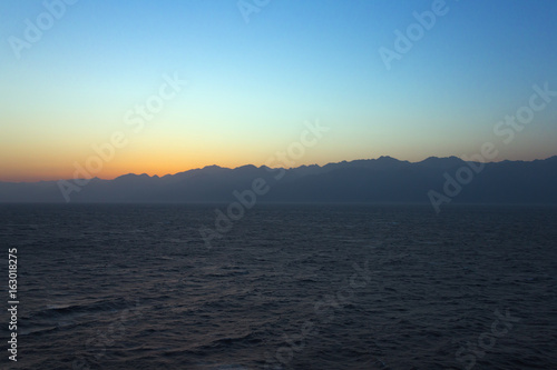 Sunrise over the Gulf of Aqaba with the sun still behind the mountains