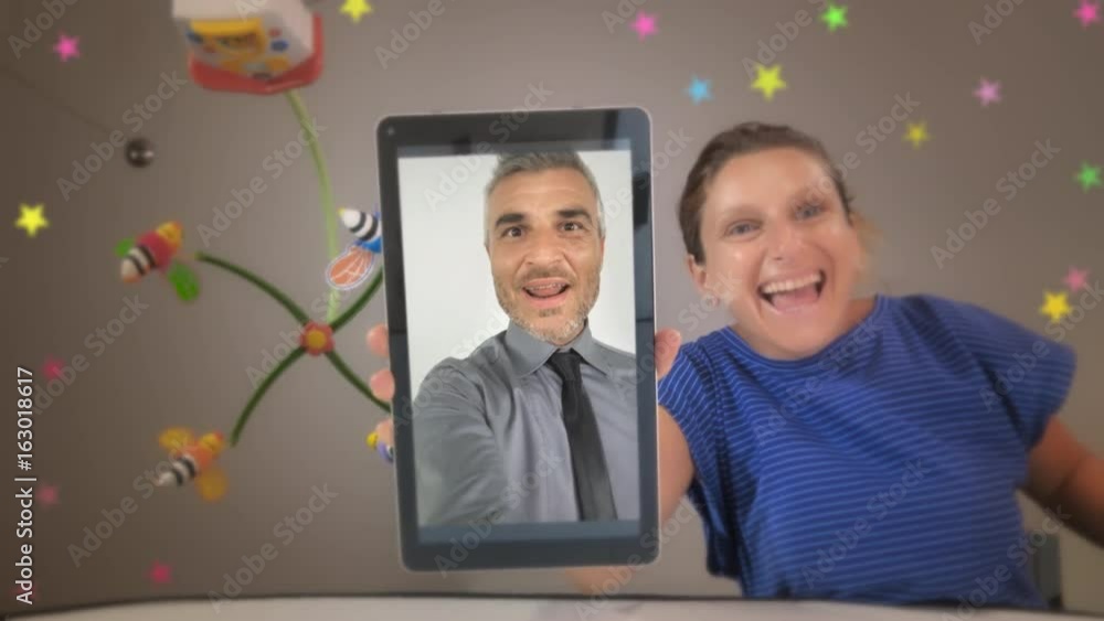 mom holding tablet show dad video calling to his baby mom holding tablet show dad video calling to his baby