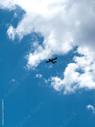 Small fire fighter airplane on blue sky
