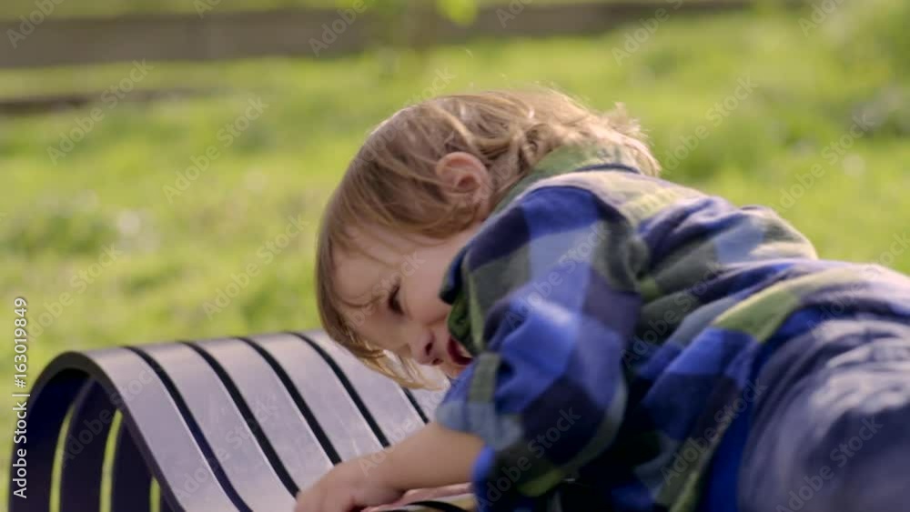 Little Boy Plays On A Park Bench Little Boy Plays On A Park Bench