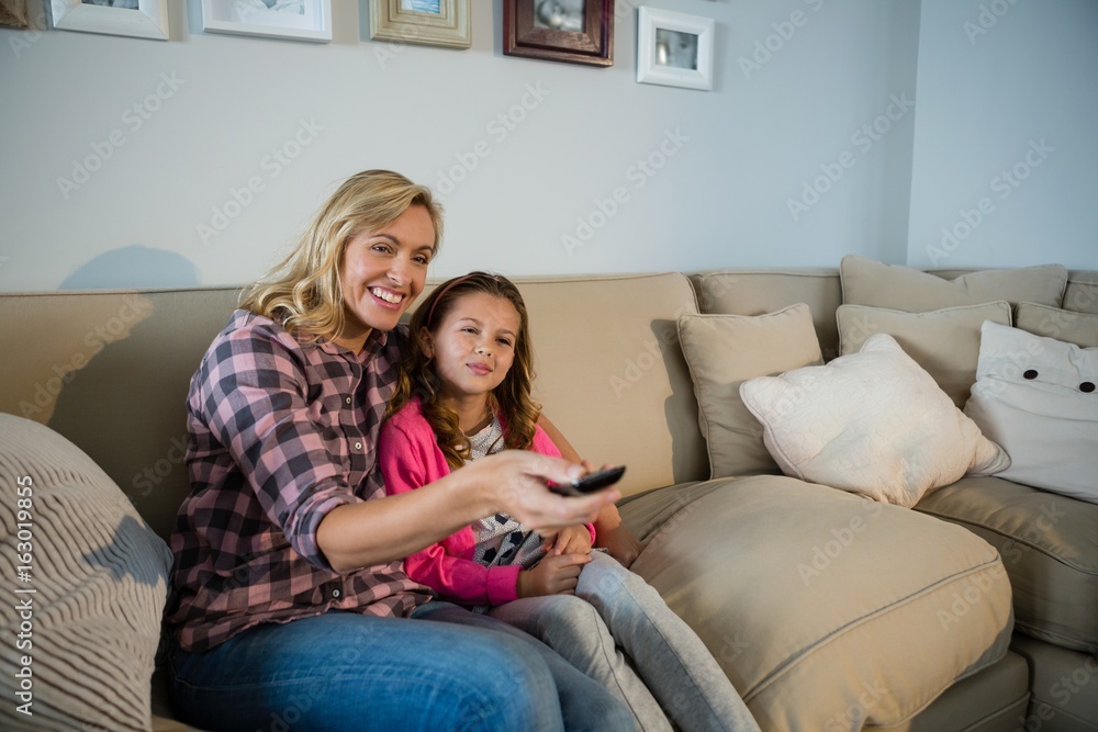 Mother and daughter watching television in the living room Mother and daughter watching television in the living room