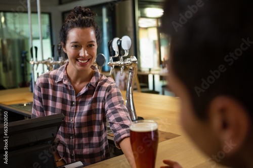 Φωτογραφία Smiling barmaid serving drink to man