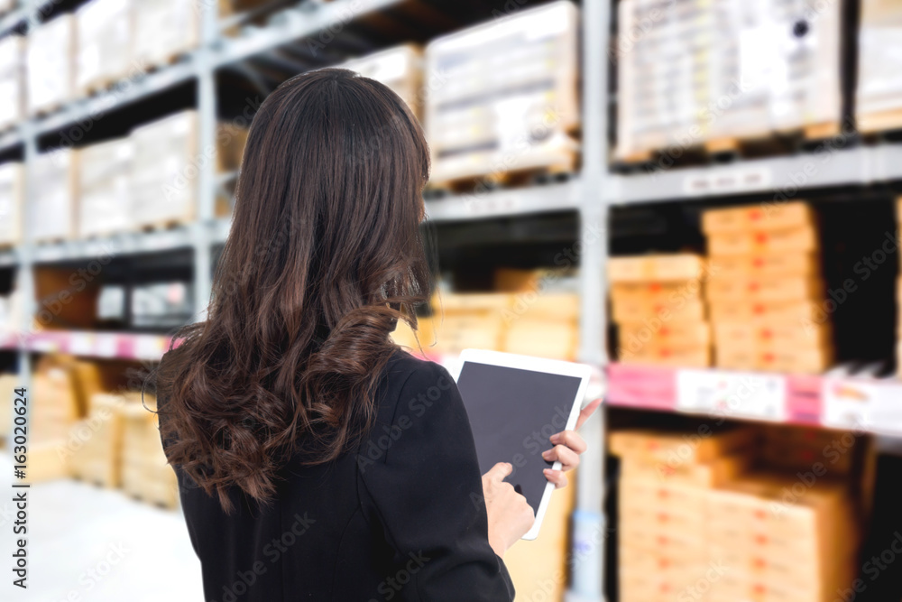 Businesswoman checking list order on a warehouse Businesswoman checking list order on a warehouse