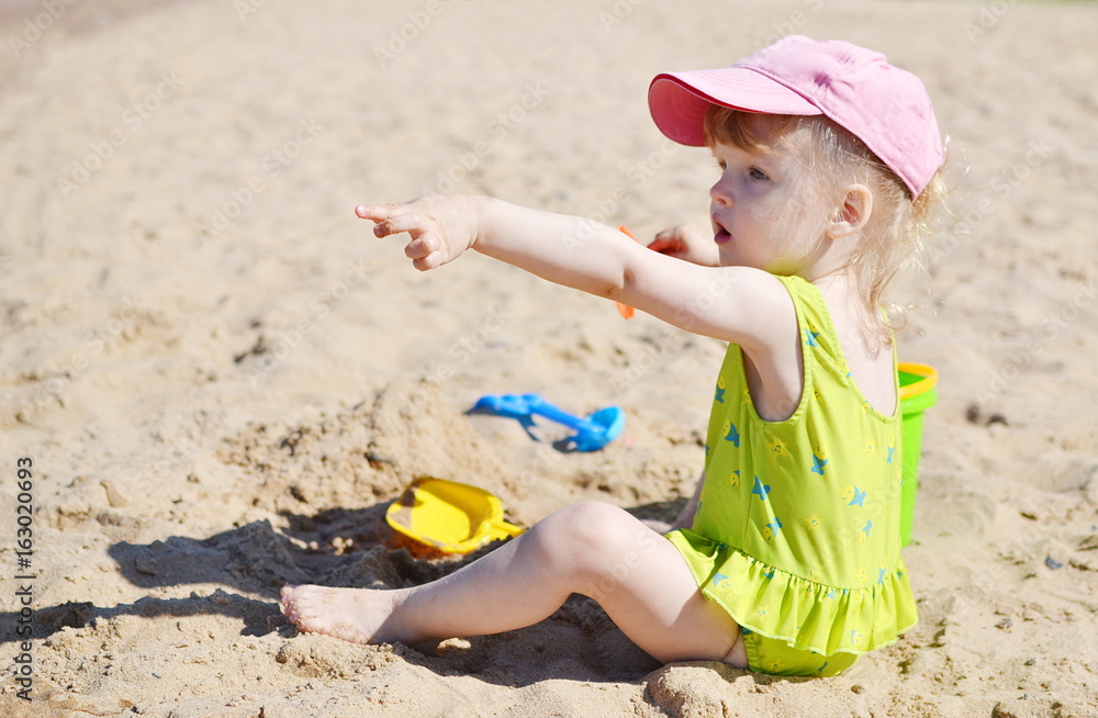 Little girl playing at the beach in sunny day