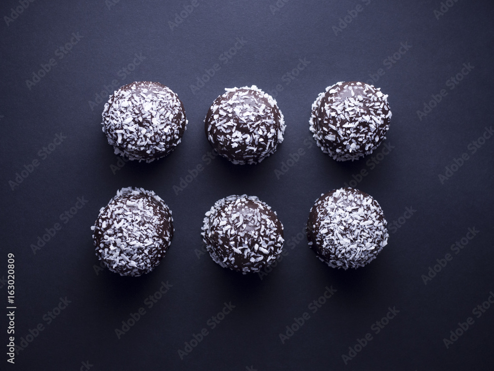 Danish floedeboller (chocolate covered marshmallows) with desiccated coconut isolated on black background Danish floedeboller (chocolate covered marshmallows) with desiccated coconut isolated on black background