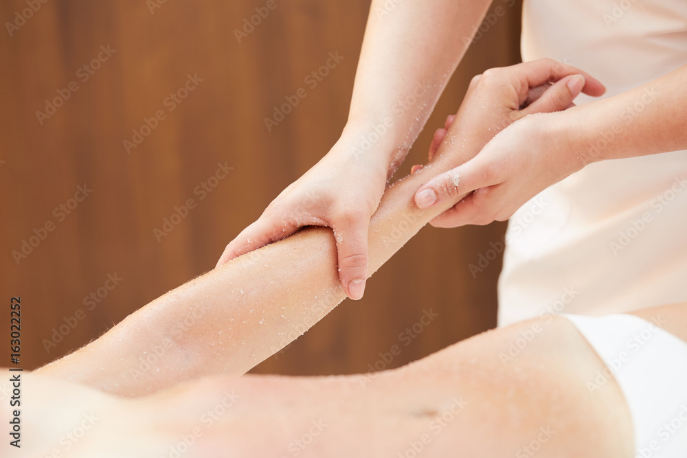 Naklejka premium Woman Getting a Salt Scrub Beauty Treatment in the Health Spa