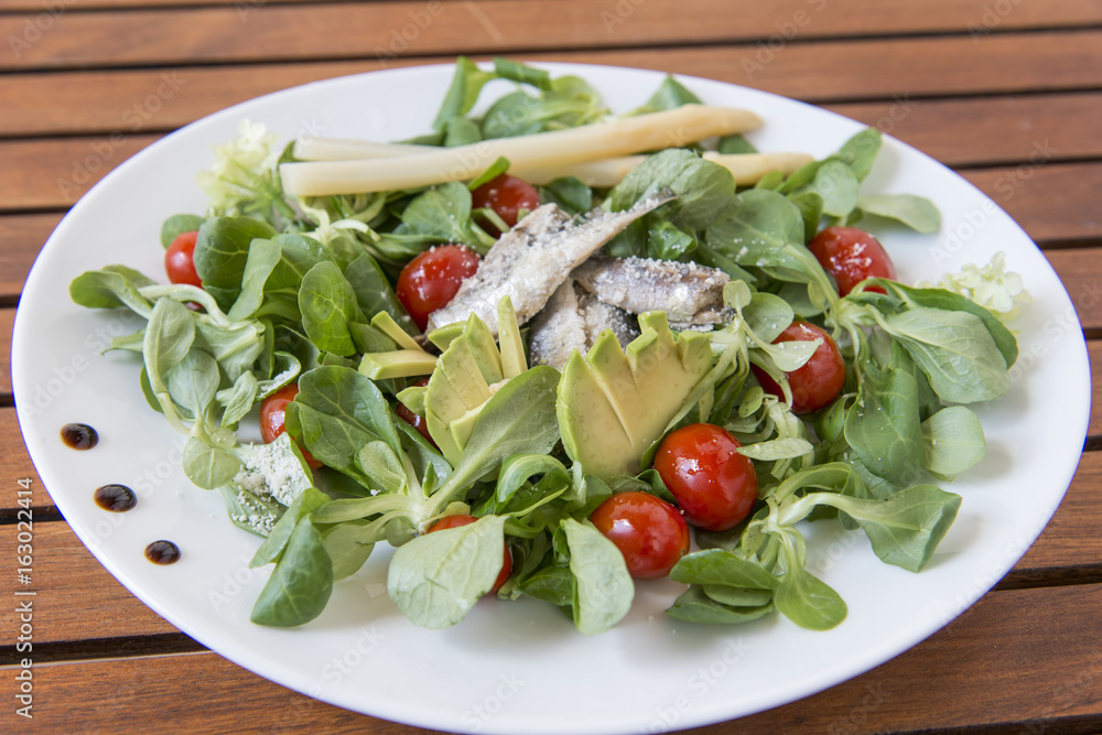 Ensalada de canónigos, con aguacates, sardinas y tomate