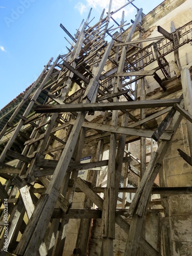 The scaffolging wood construction near the reconstructed old building on the street of Havana