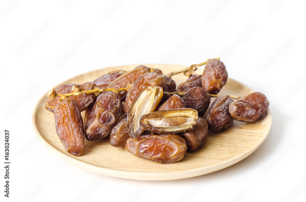 Dried date palm fruit (Deglet Noor) on wooden plate isolated on white background,Ramadan fruit