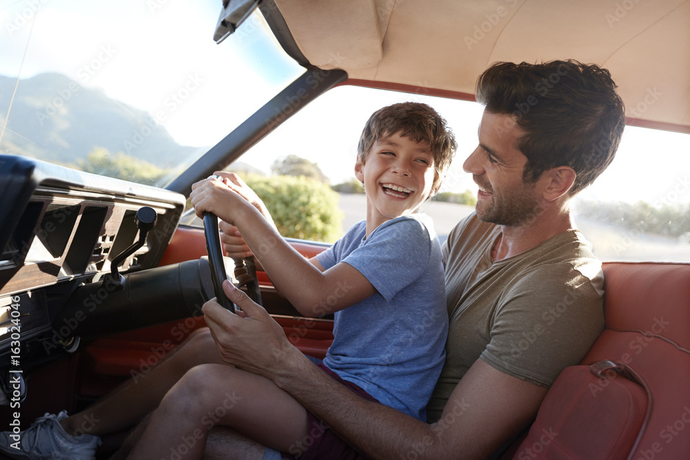 Father Teaching Young Son To Drive Car On Road Trip Father Teaching Young Son To Drive Car On Road Trip