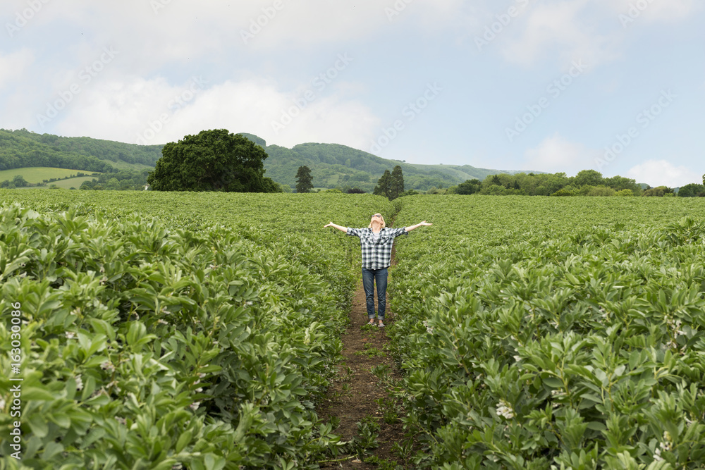 Lady Looking Up with Outstretched Arms in Middle of Field