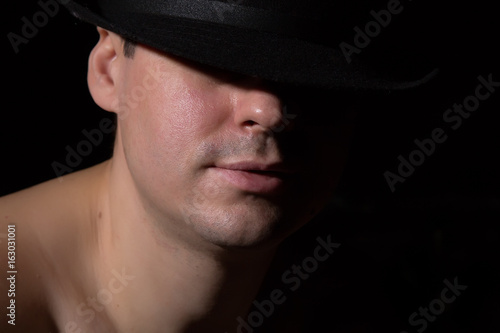 Man in a black hat with naked shoulders. Selective focus. © tasha_lyubina
