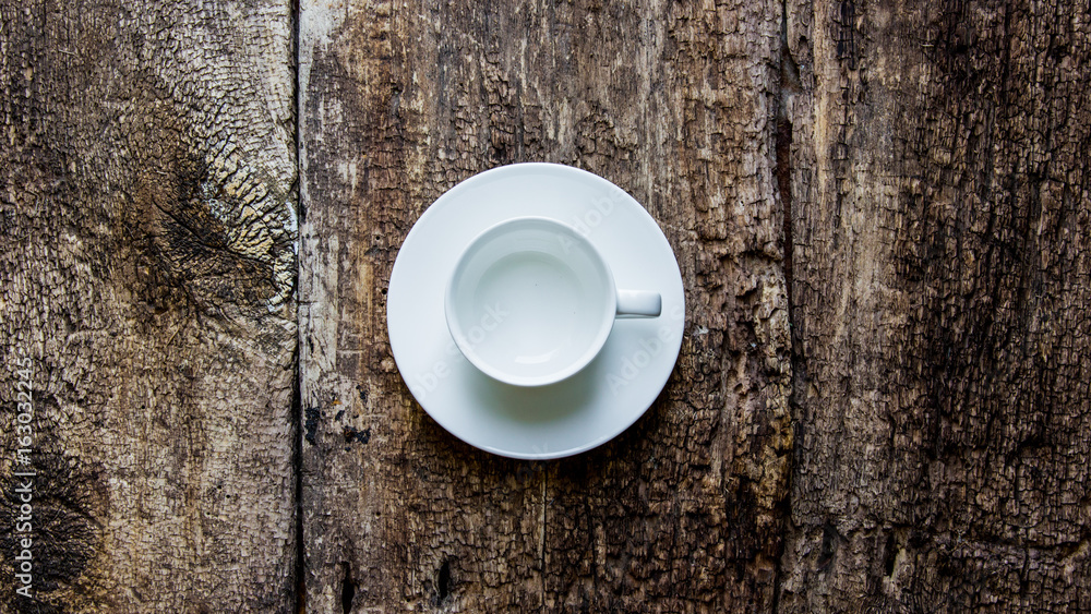 Coffee cup and saucer on old wooden table. Dark background. Coffee cup and saucer on old wooden table. Dark background.