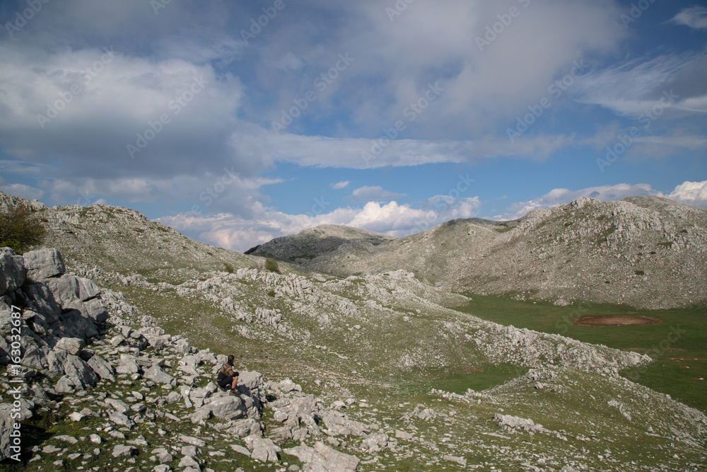 Escursionista seduto sulla montagna, Monte Cervati, Parco Nazionale del Cilento e Vallo di Diano, primavera