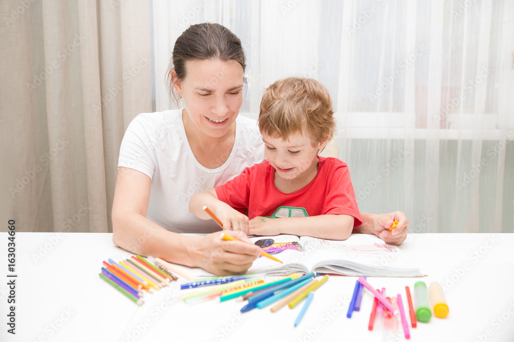 Happy family. Mother and little son together paint.