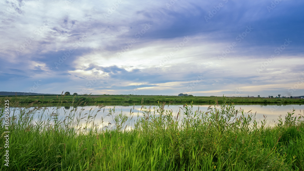 вечерний летний пейзаж на берегу уральской реки с травой, Россия, июль
