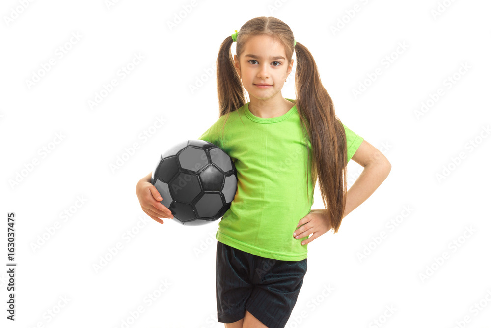 cute little girl standing in the Studio with the ball and posing