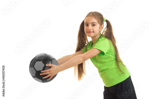 Petite athletic girl stretches the ball in her hands and smiling