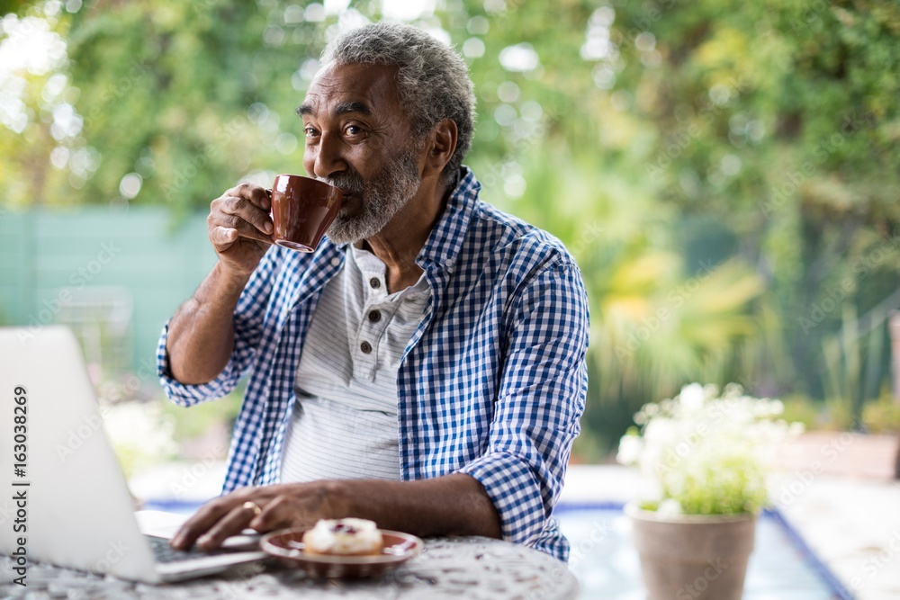 Senior man looking away while drinking coffee Senior man looking away while drinking coffee