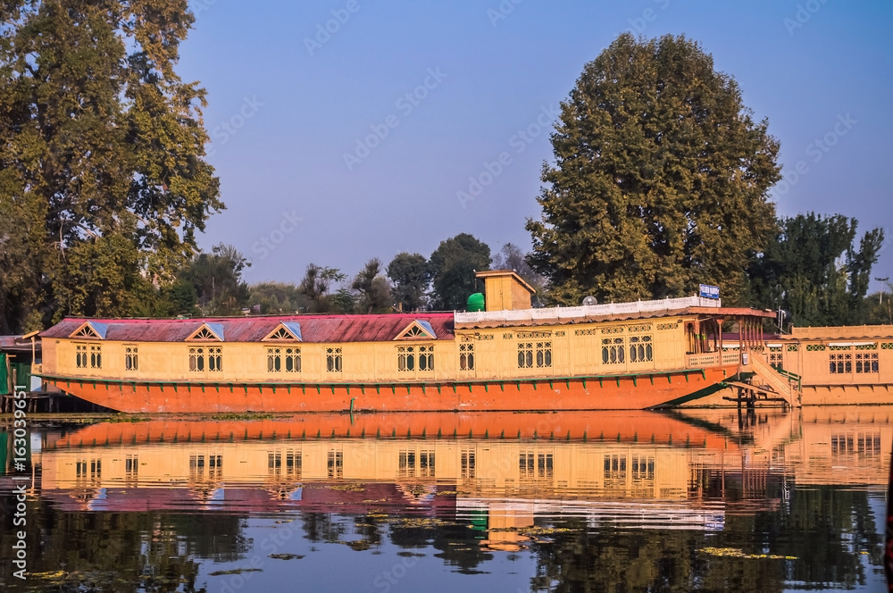 Colorful local houseboat with reflection in the lake in Kashmir, India