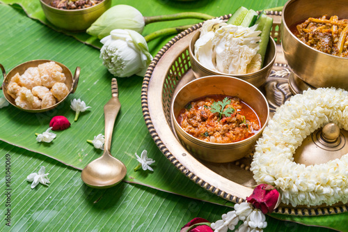A set of treaditional northern Thailand's food, served in brass ware on banana leaves decorated with flowers.
