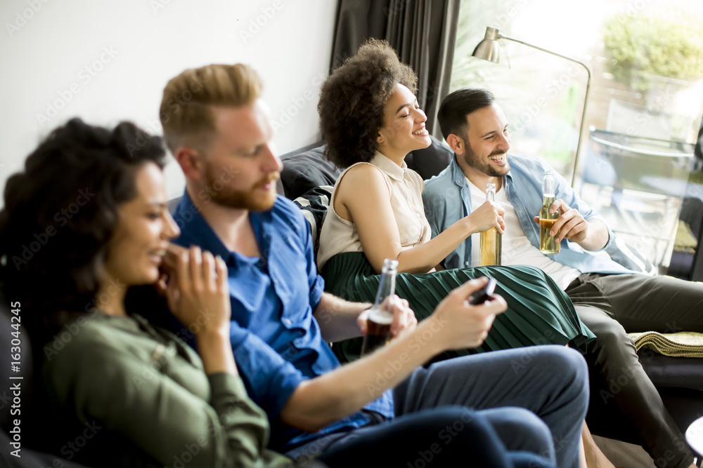 Group of friends watching TV, drinking cider and having fun Group of friends watching TV, drinking cider and having fun