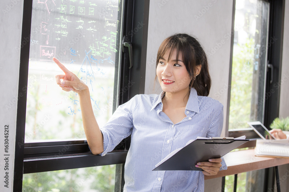 Young asian woman pointing to windows at coffee shop, 20-30 year old.