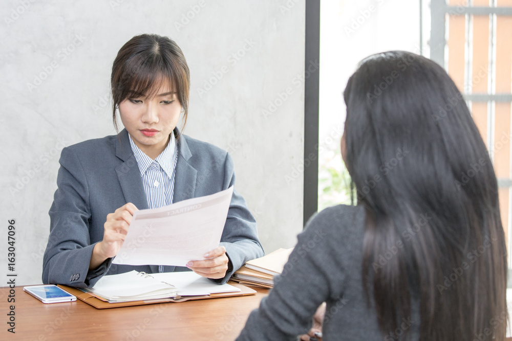 Young Asian woman arriving for a job interview. Business people takling in modern office. Greeting deal concept Young Asian woman arriving for a job interview. Business people takling in modern office. Greeting deal concept