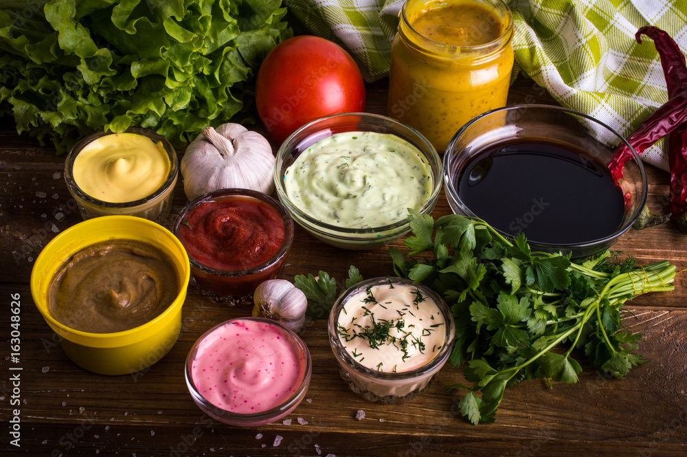 Different sauces on a wooden background Different sauces on a wooden background