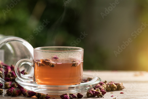 Rose tea on wood table, green background
