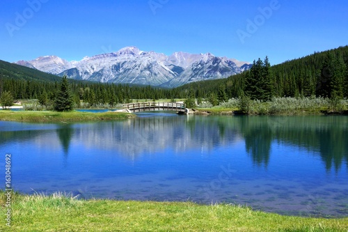 Bridge over the Cascade Ponds with blue skies and reflections  Banff National Park  Alberta  Canada