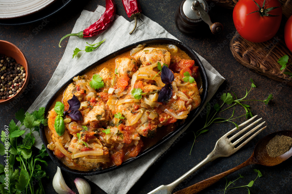Chakhokhbili - traditional Georgian dish. Stewed chicken with tomato, onion, garlic, pepper and cilantro. Selective focus. Top view. Chakhokhbili - traditional Georgian dish. Stewed chicken with tomato, onion, garlic, pepper and cilantro. Selective focus. Top view.
