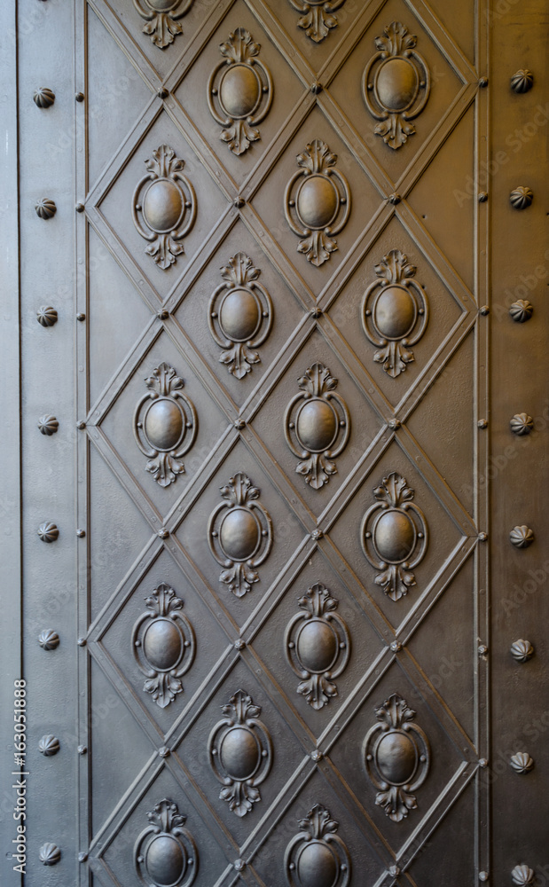 Embossed pattern on a bronze door panel Embossed pattern on a bronze door panel