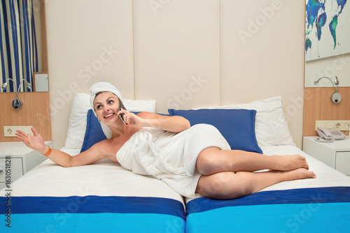 Young sexy woman in a hotel room talking on the mobile phone.