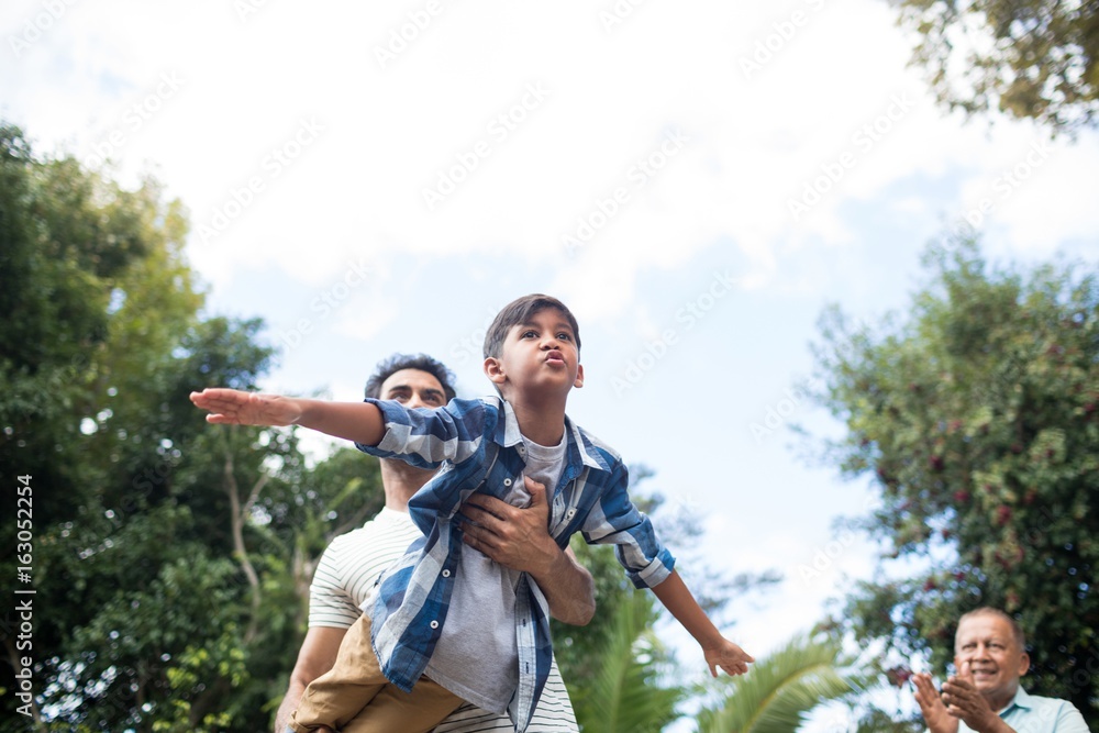 Low angle view of man looking at father playing with son Low angle view of man looking at father playing with son