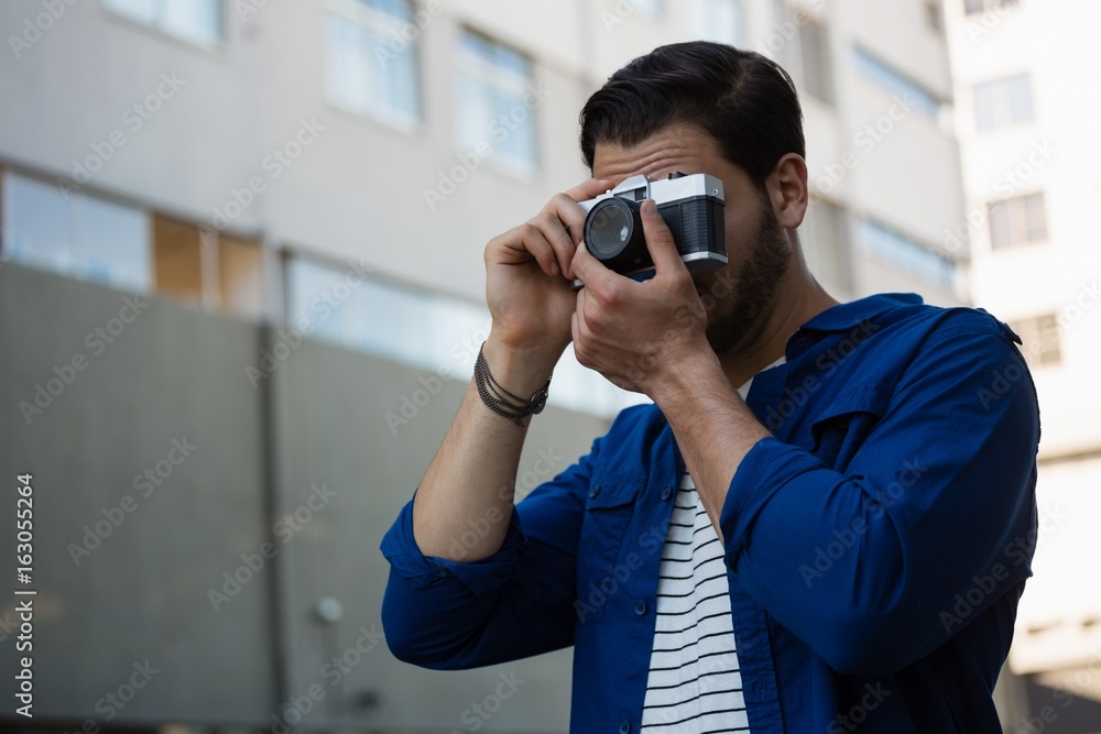 Young man photographing through camera Young man photographing through camera