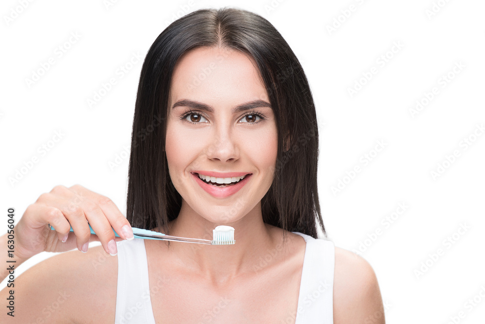 Joyful young woman is caring of her teeth