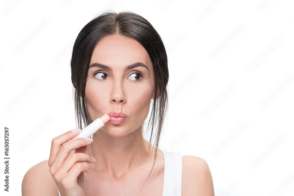 Pretty brunette woman using chapstick Pretty brunette woman using chapstick
