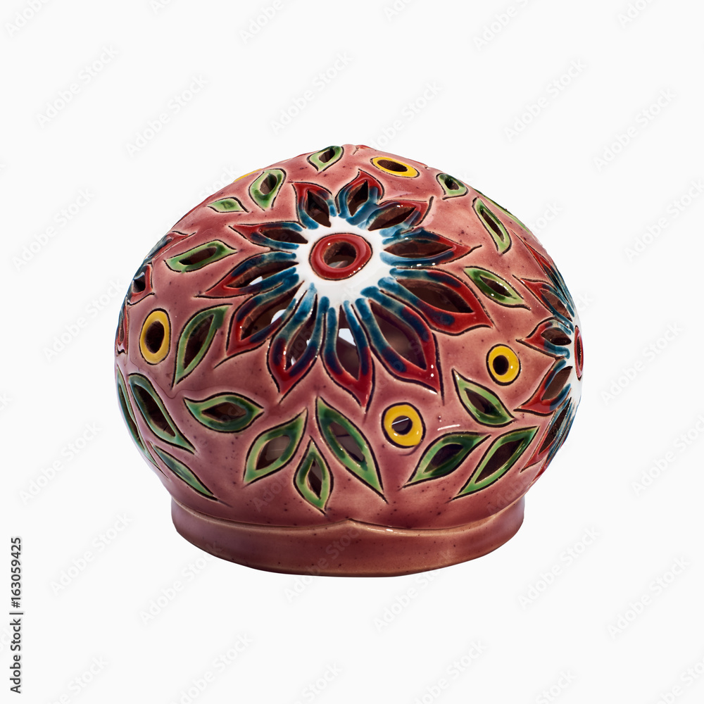 Covered with glaze colorful handmade candlestick. The candle is inserted inside the candlestick. Isolated on a white background Covered with glaze colorful handmade candlestick. The candle is inserted inside the candlestick. Isolated on a white background