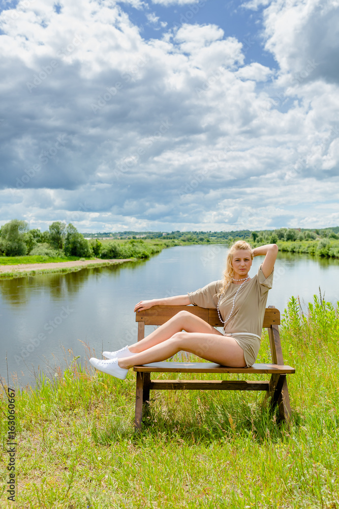 Beautiful blonde woman sitting on the bench