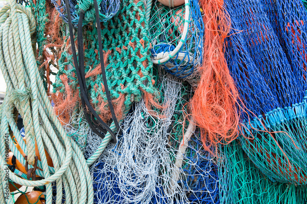 Close up on colorful and various fishing nets and ropes as a maritiem background Close up on colorful and various fishing nets and ropes as a maritiem background