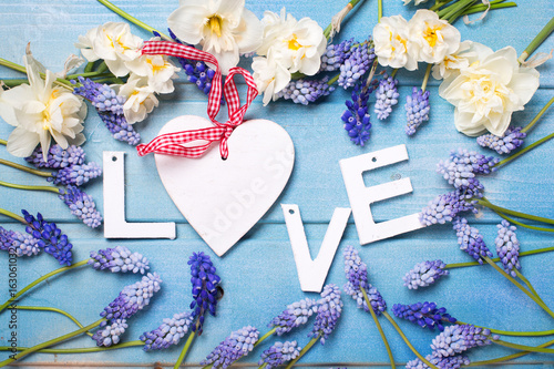 Fototapeta Naklejka Na Ścianę i Meble -  Word love and  blue and white flowers on blue wooden background.