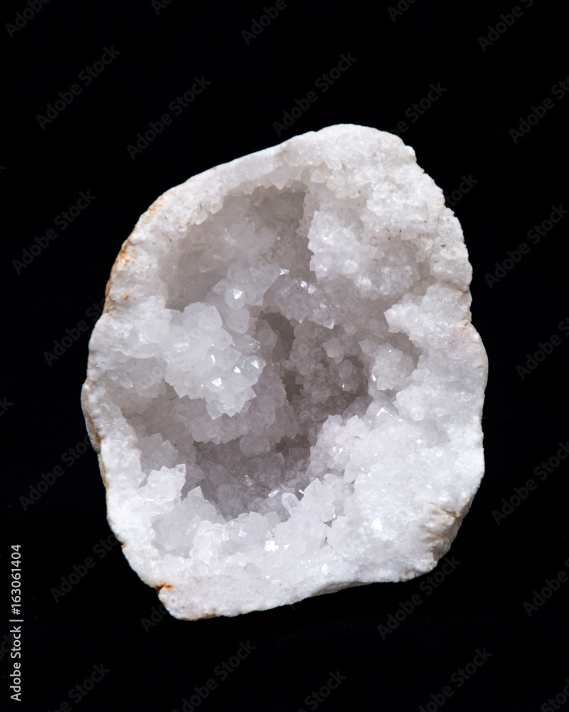 Clear crystal quartz geode with crystalline druzy center on black background Clear crystal quartz geode with crystalline druzy center on black background