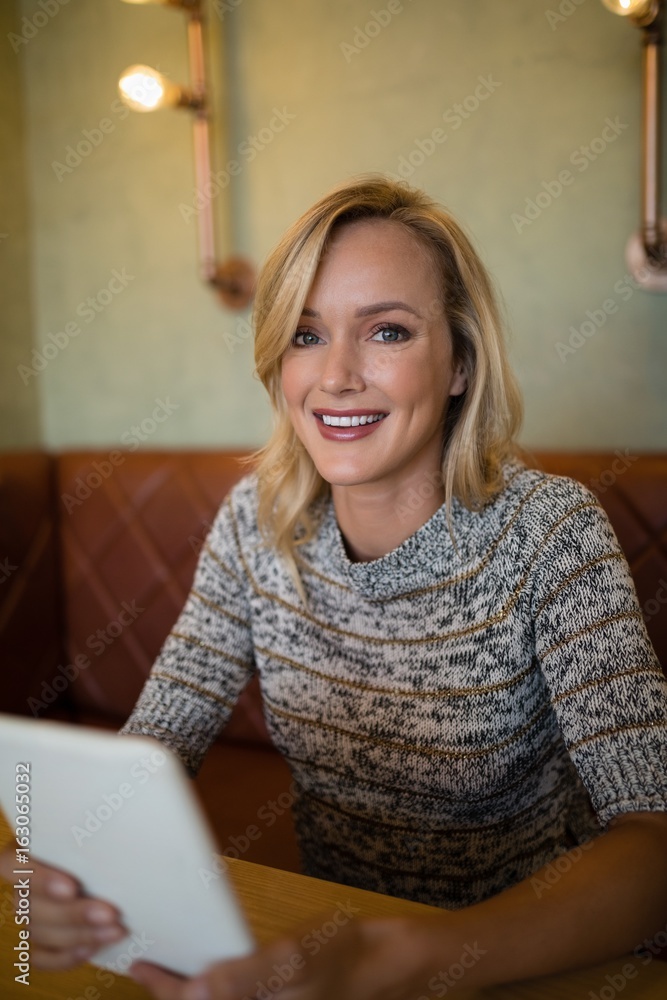 Smiling beautiful woman using digital tablet at table Smiling beautiful woman using digital tablet at table