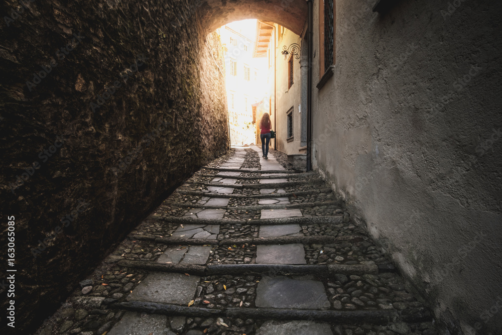 woman walk dark street narrow alley