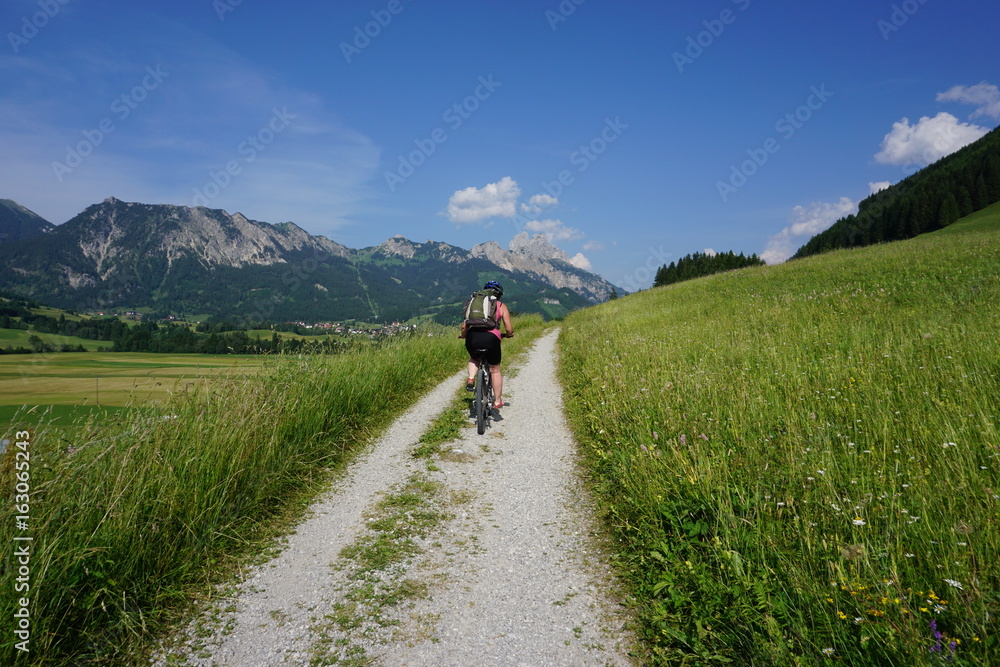 Mountainbikerin vor Bergpanorama