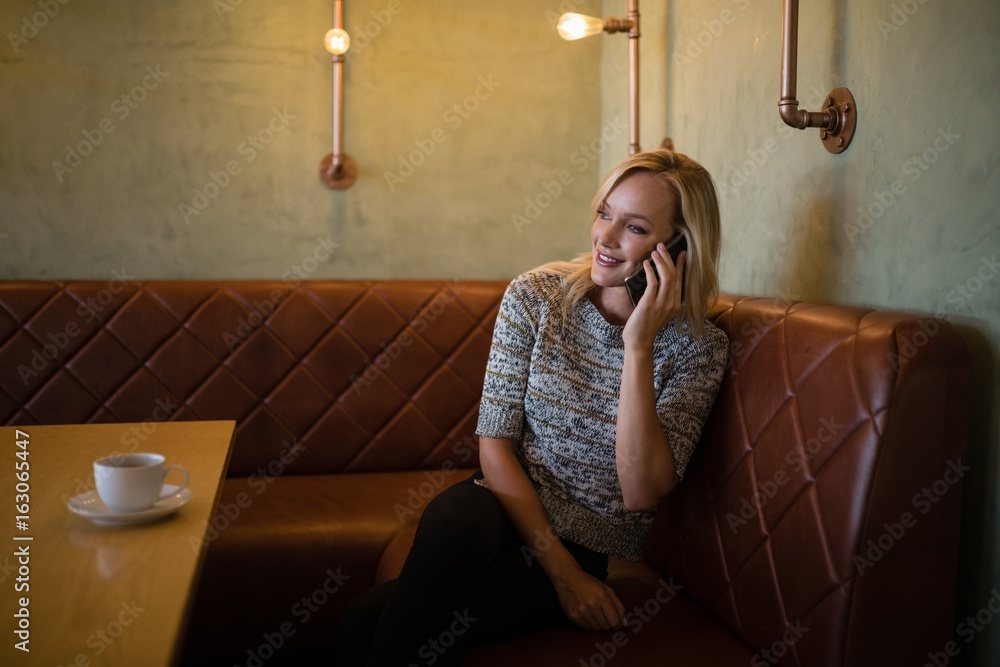 Obraz premium Beautiful woman talking on mobile phone in restaurant