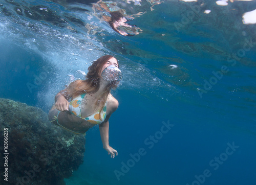 Beautiful healthy girl swims in the sea.